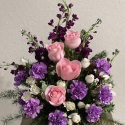 Pink roses and purple carnations in a green vase