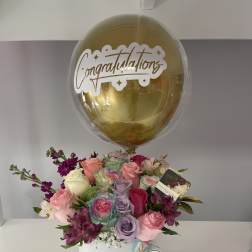 Bouquet of pastel roses in a white box with a gold congratulations balloon