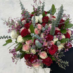 Bouquet of red, pink, and white roses with purple filler flowers