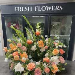 Large floral arrangement with peach, white, and pink blooms