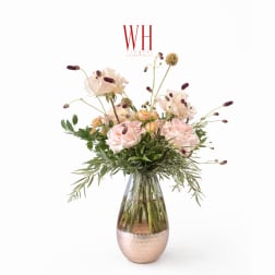 Blush roses in a glass vase with airy filler flowers