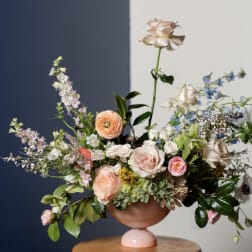 Pastel floral arrangement in a pink pedestal vase