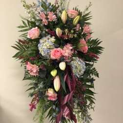 Tall standing floral spray with pink roses, lilies, and blue hydrangeas