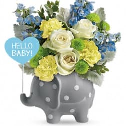 Blue and yellow flower arrangement in a gray elephant planter with a baby sign