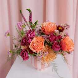 Pink and peach rose bouquet in a striped vase