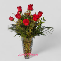 Red roses arranged in a tall mirrored vase