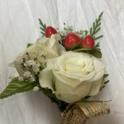 Small bouquet of white roses with red berry accents and gold ribbon