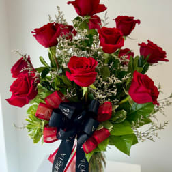 Bouquet of red roses with a black ribbon in a glass vase