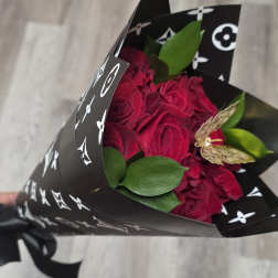 Bouquet of deep pink roses wrapped in black patterned paper