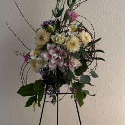 Tall floral arrangement with pink and white blooms on a stand
