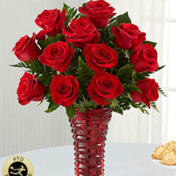 Red roses arranged in a tall red glass vase