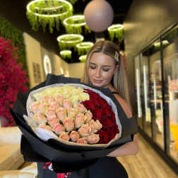 Large bouquet of pink, cream, and red roses wrapped in black paper