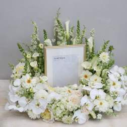 White floral frame arrangement with orchids and calla lilies