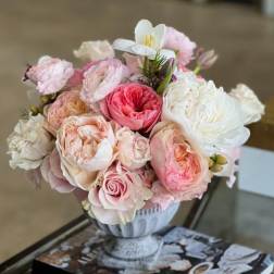 Pink and white rose bouquet in a decorative urn vase