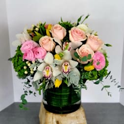 Pink roses and white orchids in a dark green vase