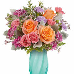 Bouquet of orange and pink roses with purple carnations in a turquoise vase