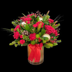 Red floral arrangement in a glass vase with a red ribbon