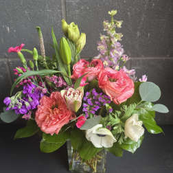 Mixed bouquet of pink and purple flowers in a clear glass vase