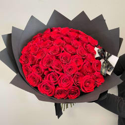 Large bouquet of red roses wrapped in black paper