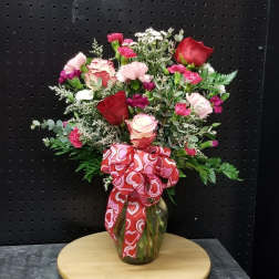 Bouquet of red and pink roses with carnations in a glass vase