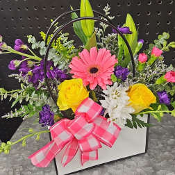 Mixed flower arrangement in a white box with a pink bow