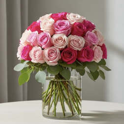 Pink and white roses arranged in a clear glass vase