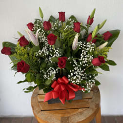 Bouquet of red roses and white lilies with baby's breath in a black box