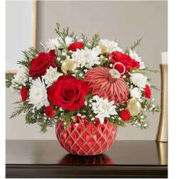 Red roses and white daisies in a red patterned vase with gold ornaments