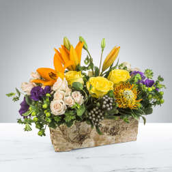 Rustic box arrangement with orange lilies, yellow roses, cream spray roses and purple blooms.