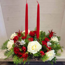 Red candles in a holiday arrangement of red and white roses