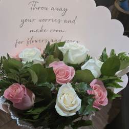 Bouquet of pink and white roses with a scalloped card