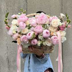 Large basket of pink and white flowers with ribbon streamers