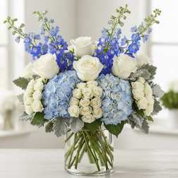 Blue and white floral arrangement in a clear glass vase