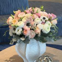Pastel bouquet of roses and ranunculus in a white vase