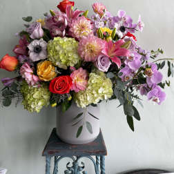 Mixed bouquet in a white vase with pink, purple, and red blooms