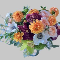 Colorful bouquet with orange dahlias, pink roses, and white anemones