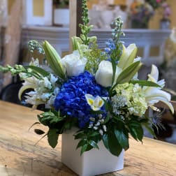 Blue hydrangea and white lilies in a white square vase