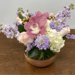 Pink orchid and pastel flowers in a copper bowl vase