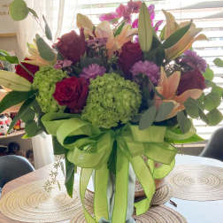Mixed bouquet of lilies, roses, hydrangeas, and orchids in a vase