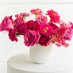 Pink and magenta mixed bouquet in a white textured vase