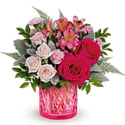 Pink and white rose bouquet in a pink glass vase