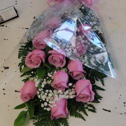 Pink rose bouquet wrapped in clear plastic with a pink bow