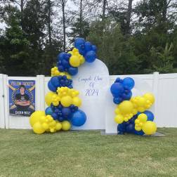 Blue and yellow balloon display around a graduation sign