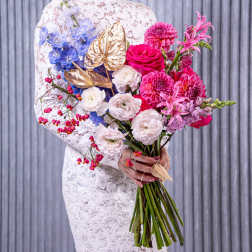 Woman holding a colorful bouquet with pink, white, and blue flowers