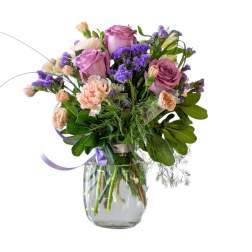 Bouquet of lavender roses and peach carnations in a glass vase