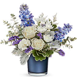 White roses and blue flowers arranged in a blue vase