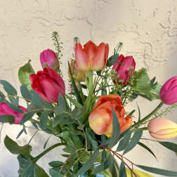 Bouquet of pink and orange tulips in a glass vase