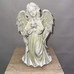 White angel figurine holding a small bird