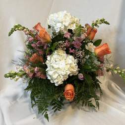 Bouquet of white hydrangeas and orange roses in a vase
