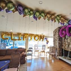 Balloon decorations spelling "CLIFTON" and "60" in a living room